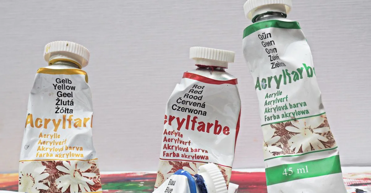 Gros plan sur des tubes de peinture acrylique colorés sur une toile, idéal pour les projets artistiques et de bricolage.