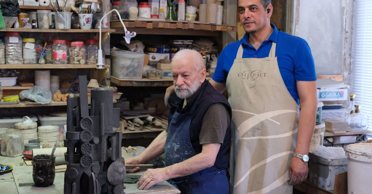 Sculpteur âgé et jeune apprenti travaillant l'argile dans un studio d'artisan.