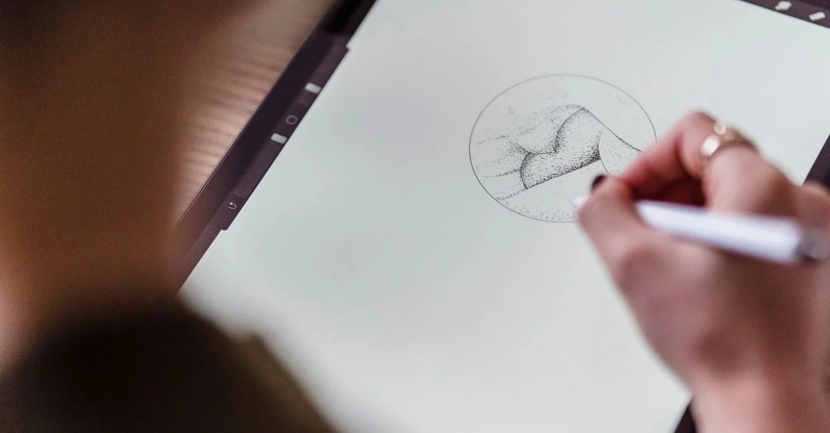 Gros plan sur une main esquissant sur une tablette, mettant en valeur des techniques d'art numérique modernes.