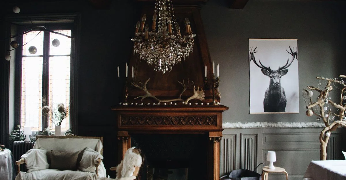 Un salon chaleureux avec une décoration vintage, incluant un lustre, une cheminée et des bois de cerf.
