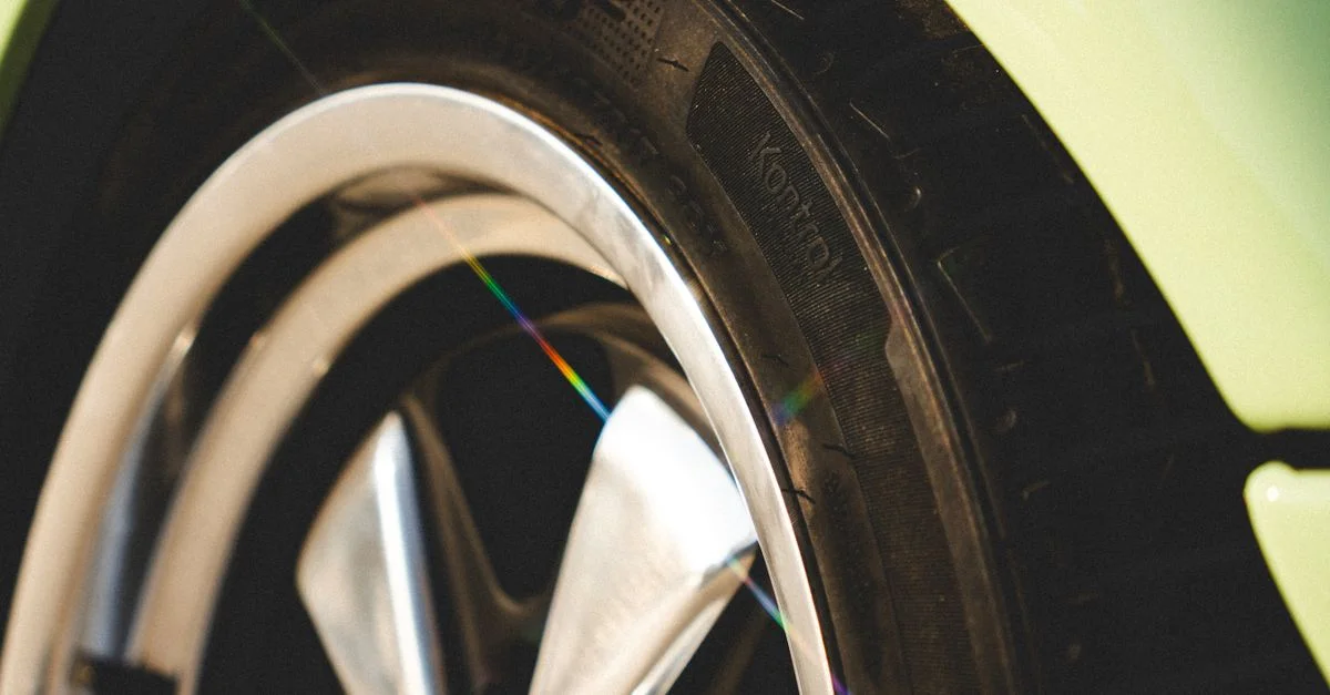 Vue détaillée d'un pneu automobile et d'une jante en alliage sous la lumière du soleil, mettant en évidence le design et la texture.